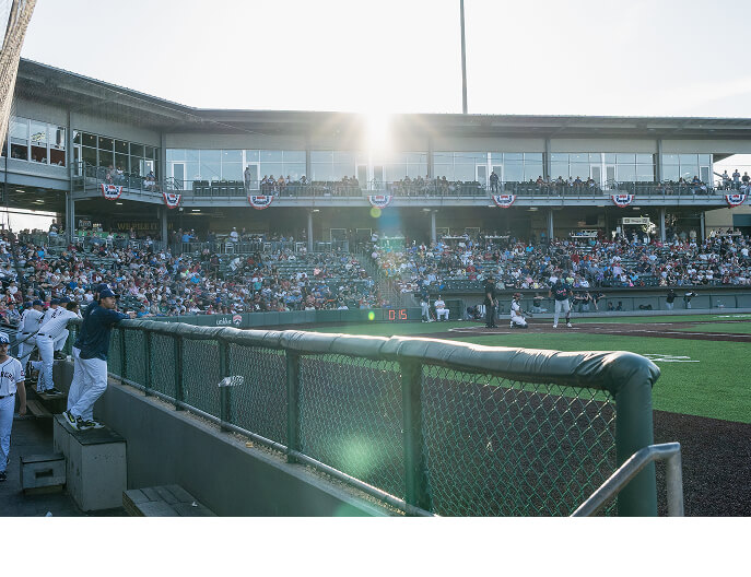 A view from the dugout looking at home plate at a stadium